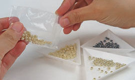 Beads being poured into sorting tray